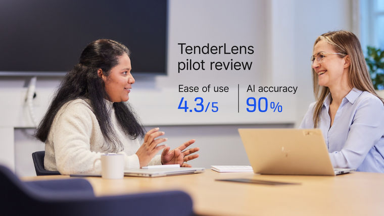 Two women with computers discussing in meeting room.