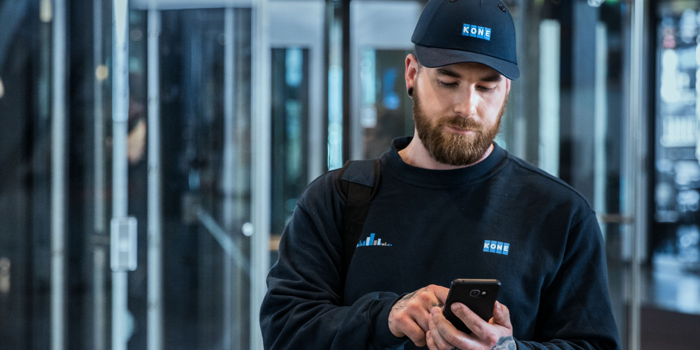 KONE service technician using smartphone.