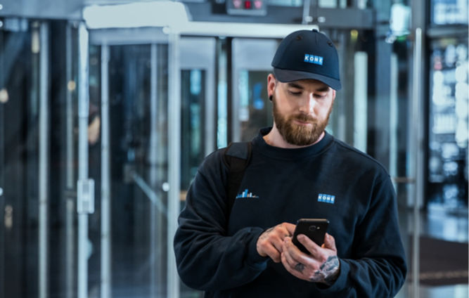 KONE service technician using smartphone.