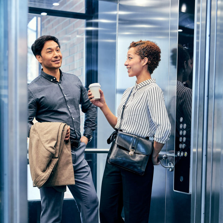 Two people discussing in elevator.