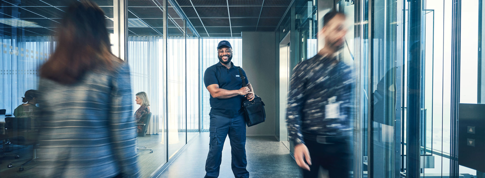 KONE service technician standing in a modern glass office.