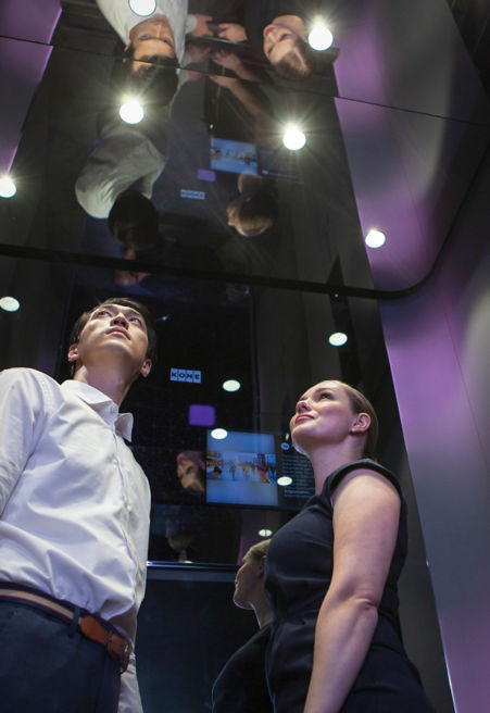 Dos personas dentro de cabina de elevador - KONE Clase DX