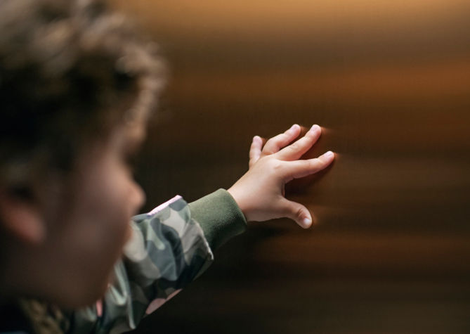 Niño tocando el muro del interior de un elevador