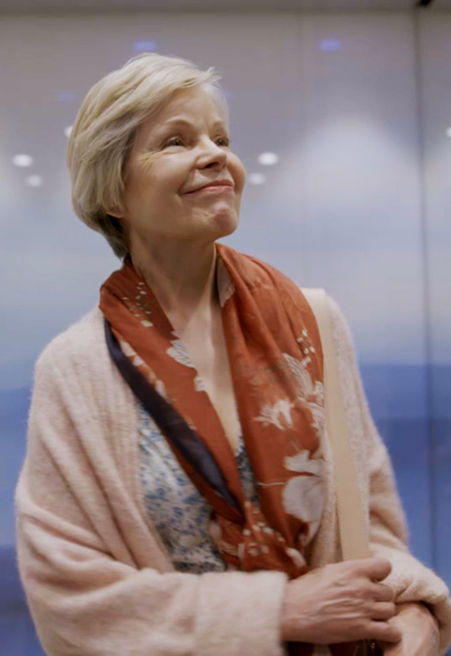 Older lady looking happy in the lift.