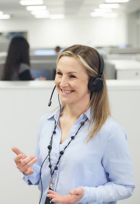 KONE customer service employee talking with customer through a headset.