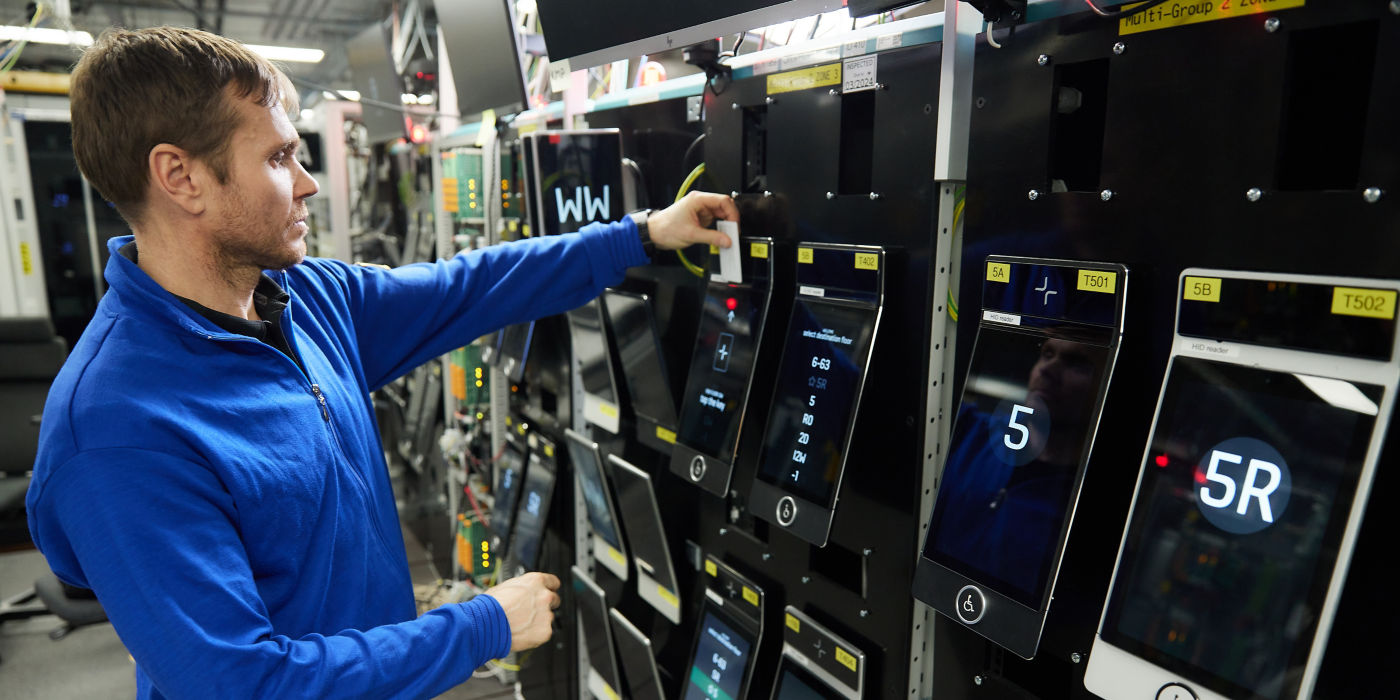 Man testing KONE's destination operating panels in research and development facility.