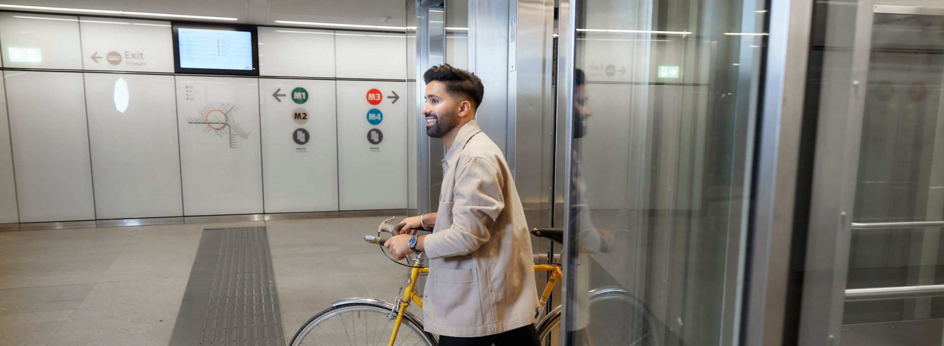 Man with bike walking out of the elevator at a metro station