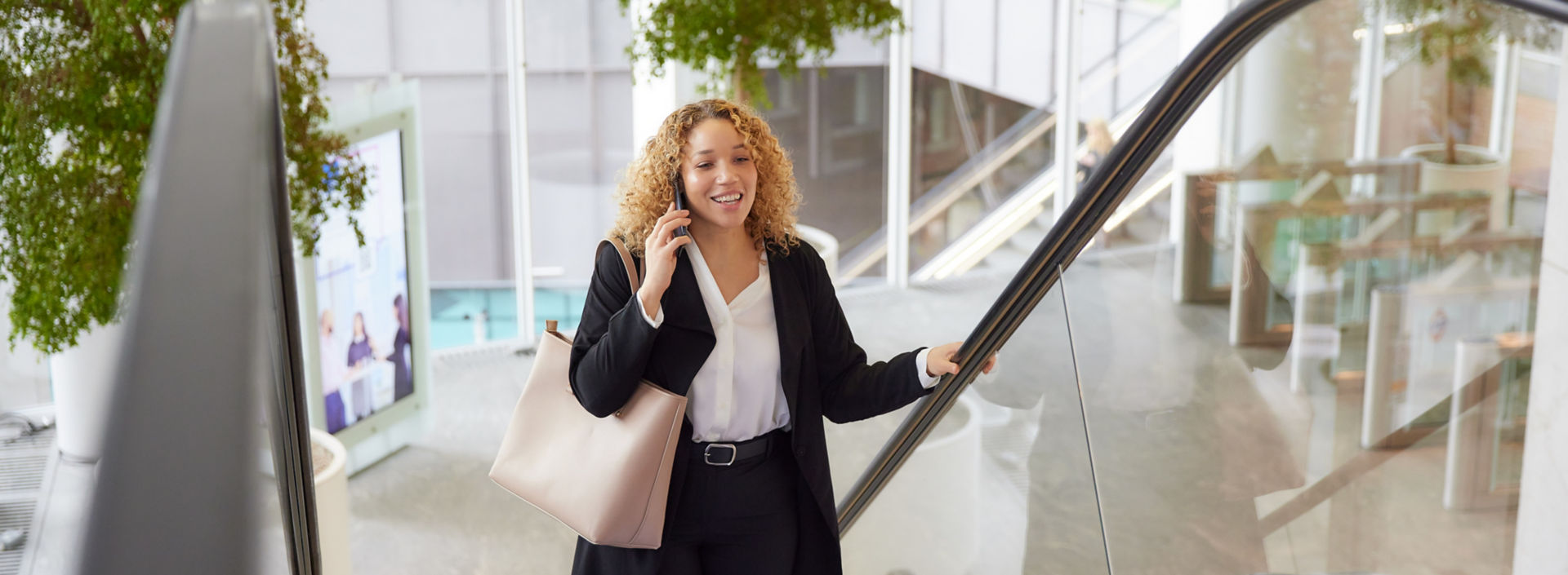 KONE - femme empruntant un escalator tout en téléphonant