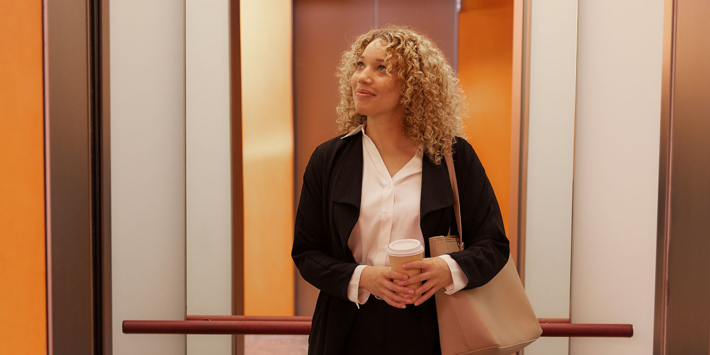 Woman standing in an elevator while observing the interior of the elevator
