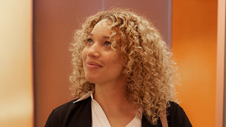 Woman standing in an elevator while observing the interior of the elevator
