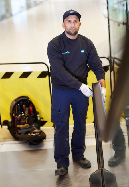 Technician checking the escalator handrail.