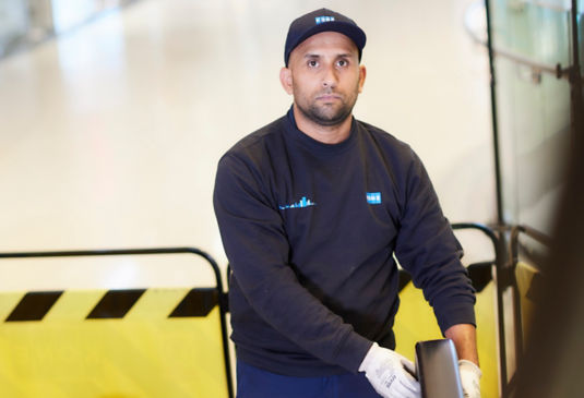 Technician checking the escalator handrail.