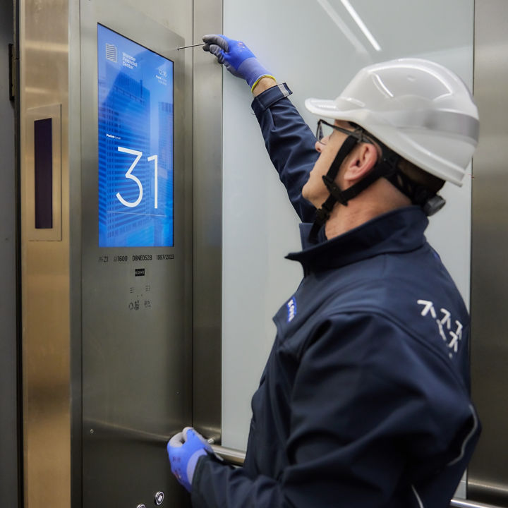 Técnico dando mantenimiento al interior de un elevador KONE