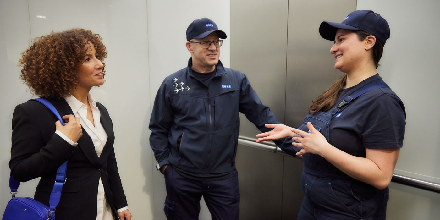 Two KONE Technicians talking to a person inside an elevator