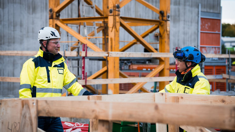Two construction workers discussing at construction site.
