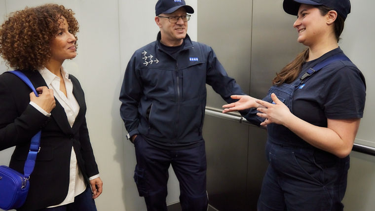 KONE technicians talking with women in elevator