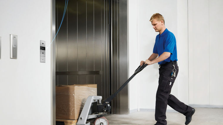 Man stepping into elevator with trolley