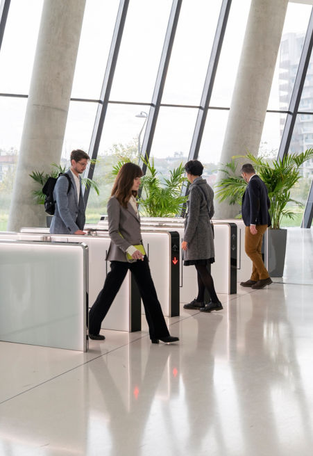 People going through an office lobby security gate - KONE