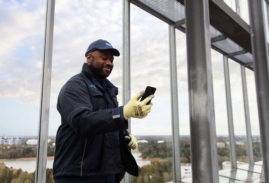 KONE technician looking at mobile phone