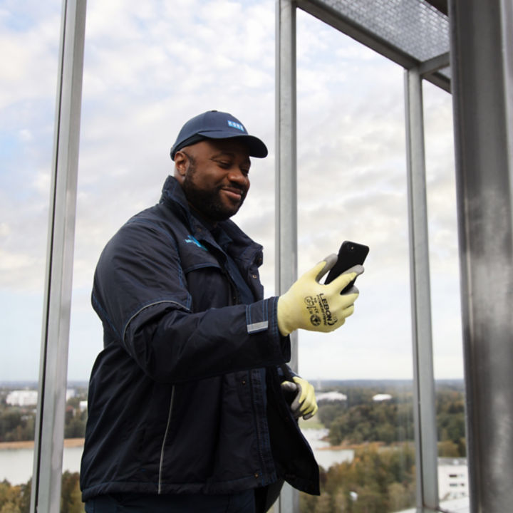 KONE technician looking at mobile phone