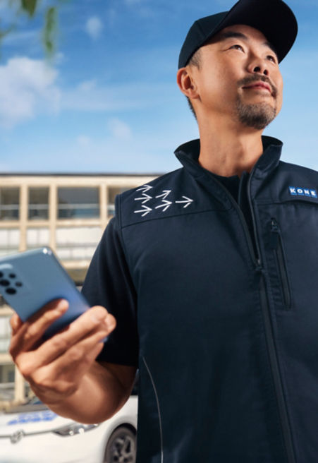 Empleado de KONE sosteniendo un smartphone