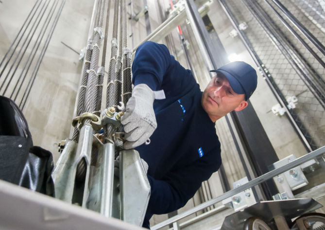Técnico KONE revisando guías del elevador