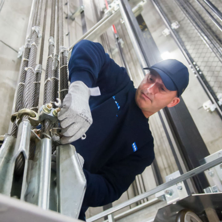 Técnico KONE revisando guías del elevador