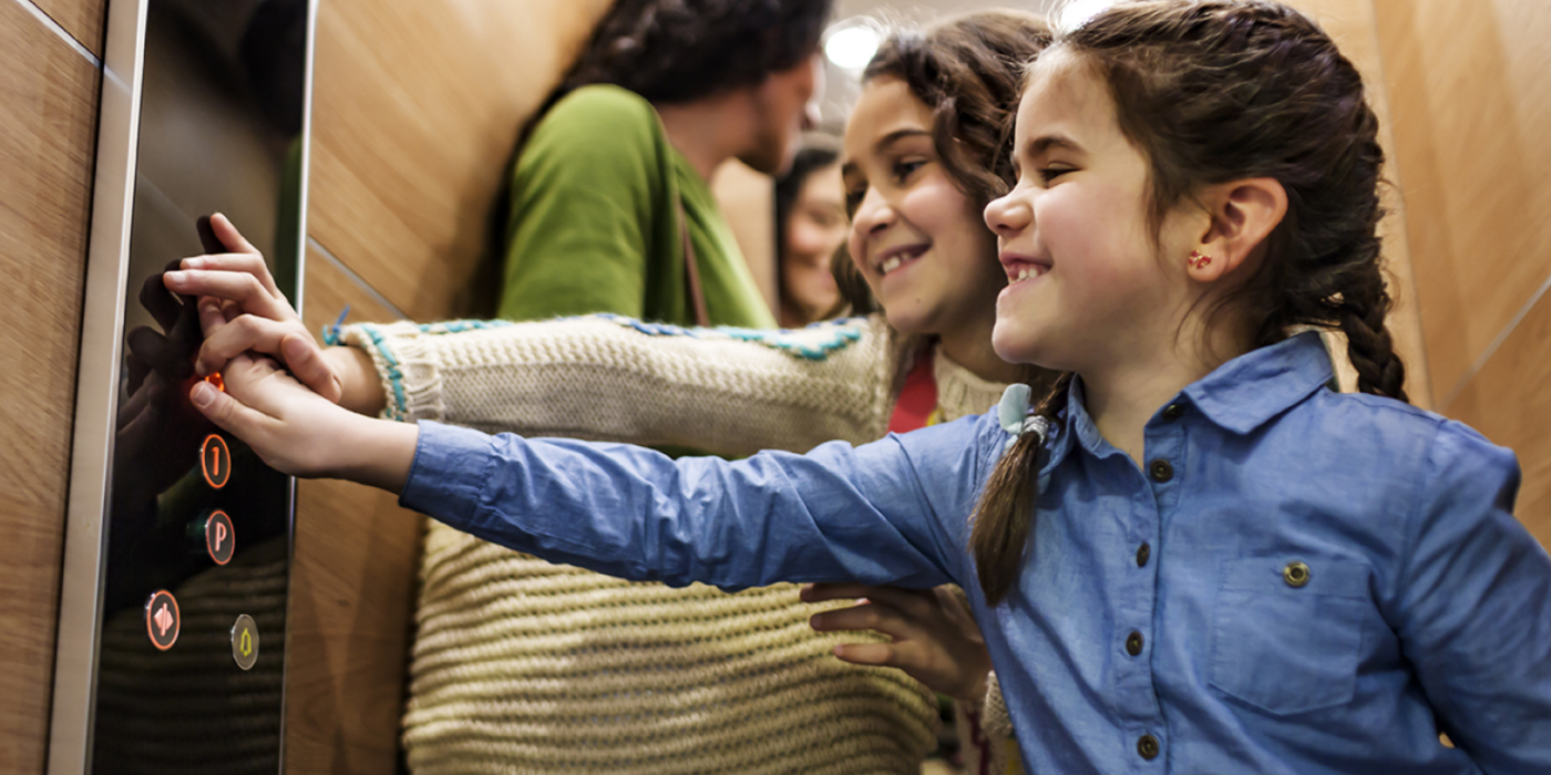 Kids selecting the floor by pushing elevator buttons - KONE Modernization