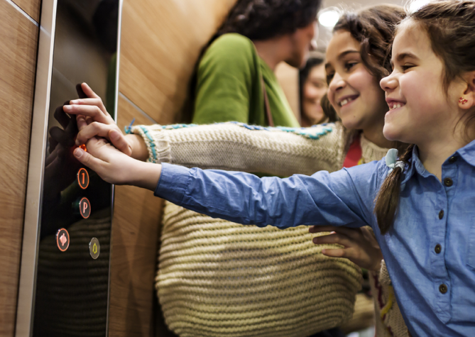 Kids selecting the floor by pushing elevator buttons - KONE Modernization