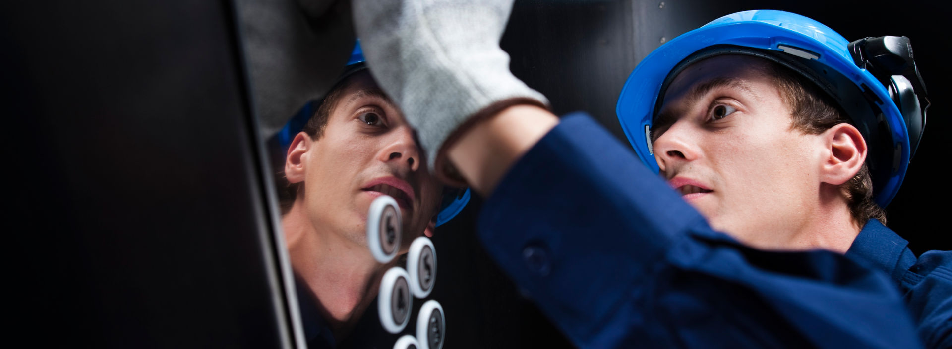 Young service technician working on elevator.