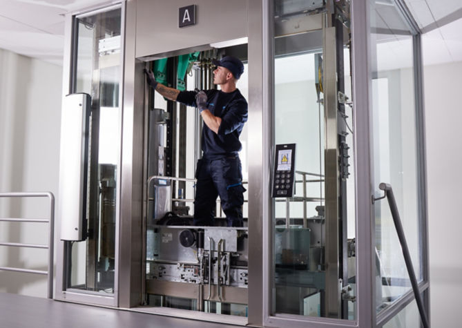 Técnico KONE instalando/verificando elevador