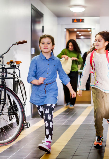 Two girls running in corridor.