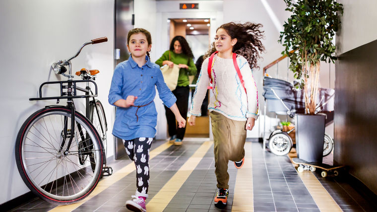 Two girls running in corridor.