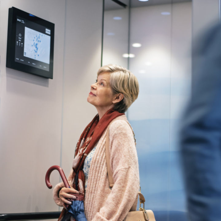 Woman with an umbrella inside elevator - KONE Services
