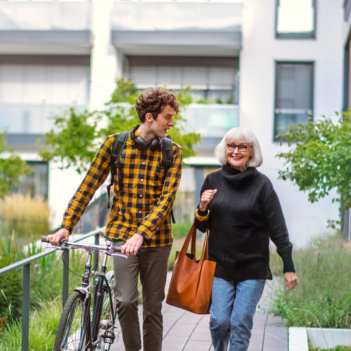 Man with a bicycle walking with woman outside - KONE Services