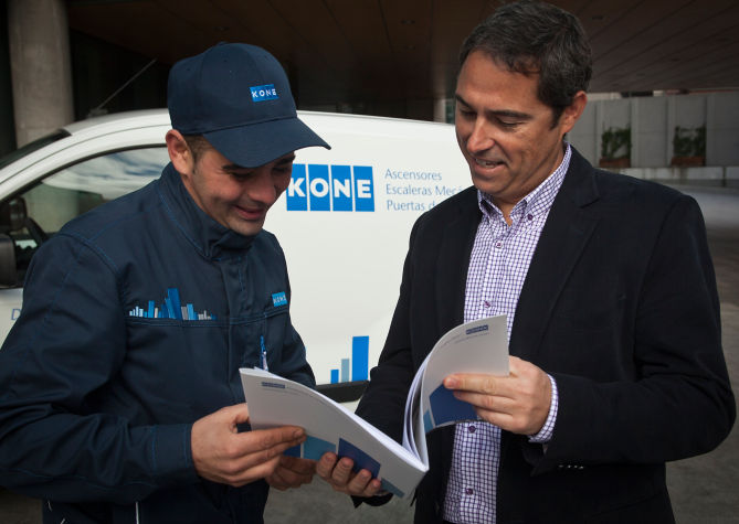 Personal de KONE con cliente viendo documento