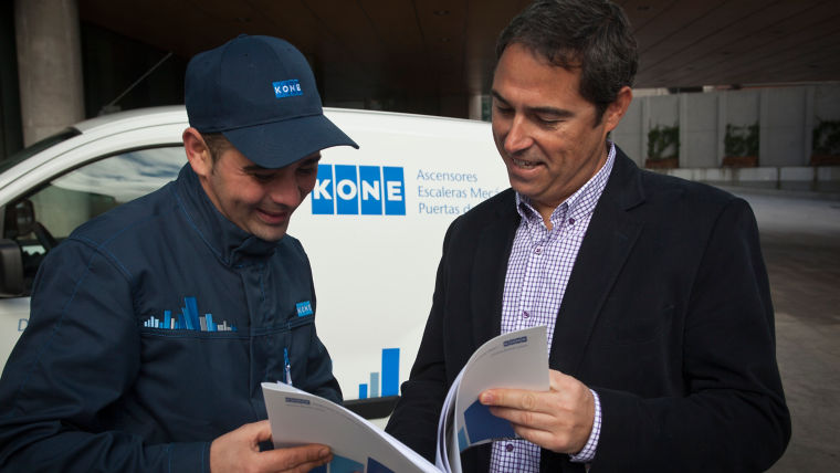 Técnico de KONE con cliente viendo documento