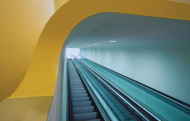 Escaleras eléctricas debajo de estructura amarilla