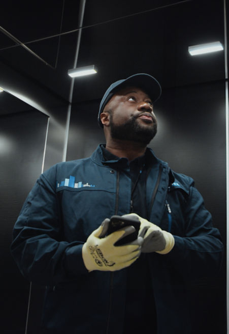 Tech-in-elevator-with-phone:451x656%2811-16%29