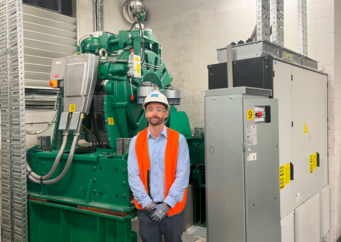 Technician_standing_near_energy_efficient_machines:669x475