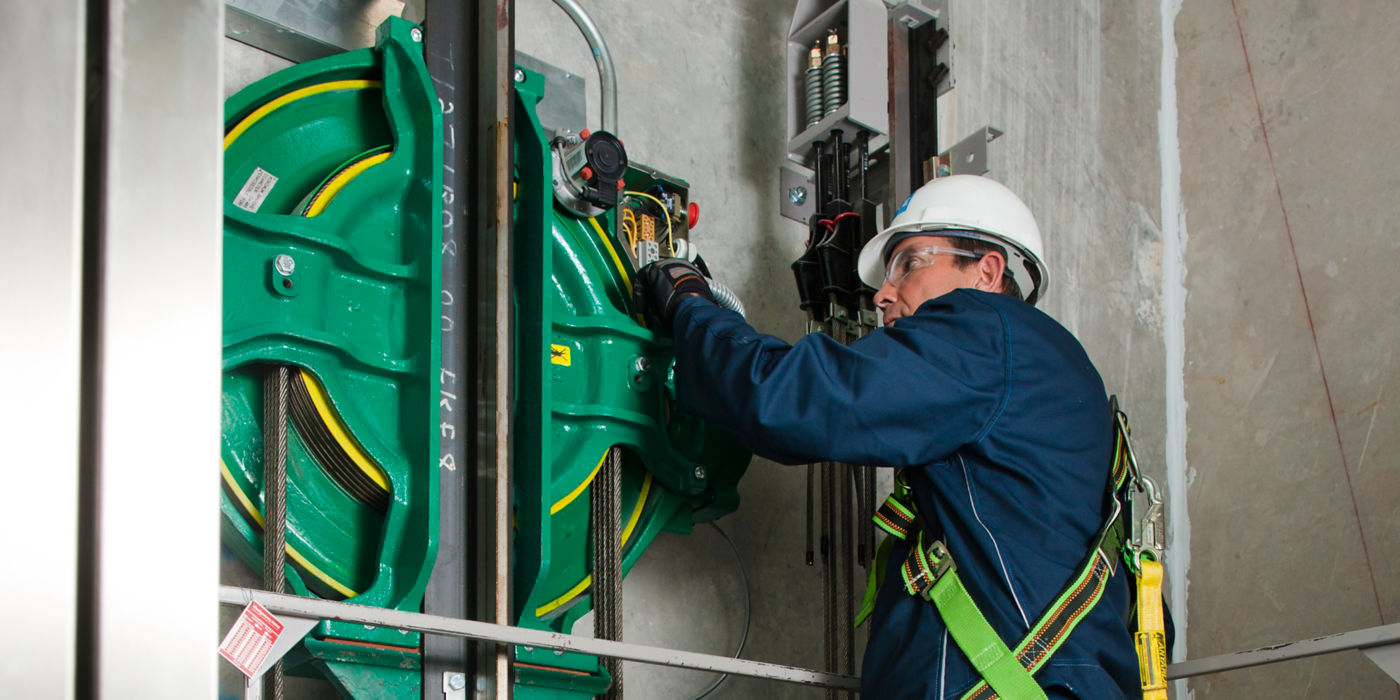 Service technician inside elevator shaft fixing KONE EcoDisc.