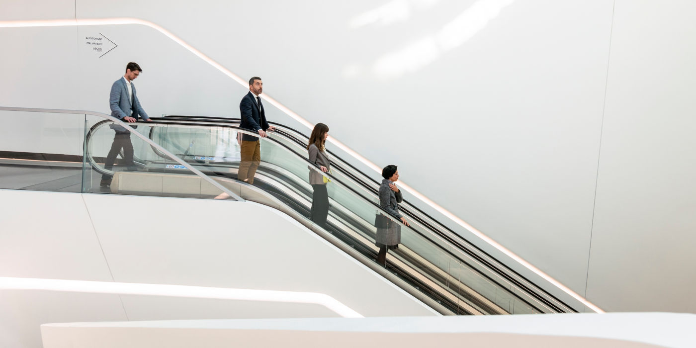 Personas bajando en escaleras eléctricas