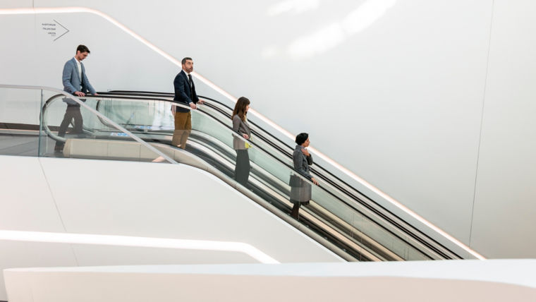 Personas bajando en escaleras eléctricas