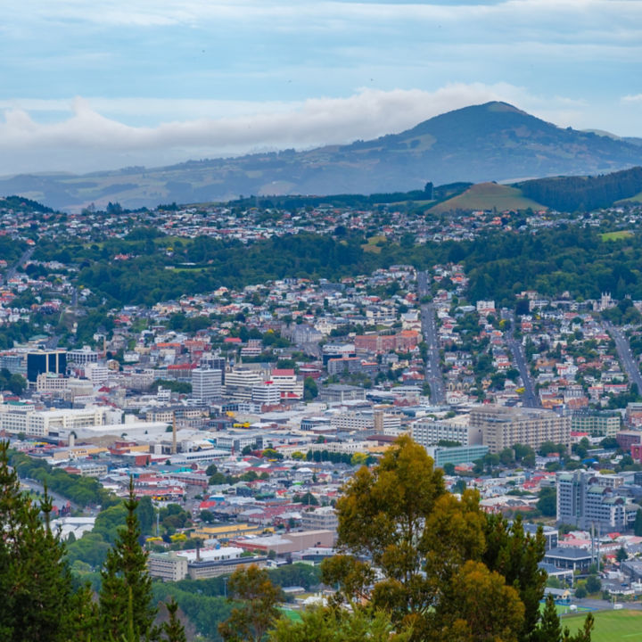 Aerial view of downtown Dunedin in New Zealand with hills in the background.