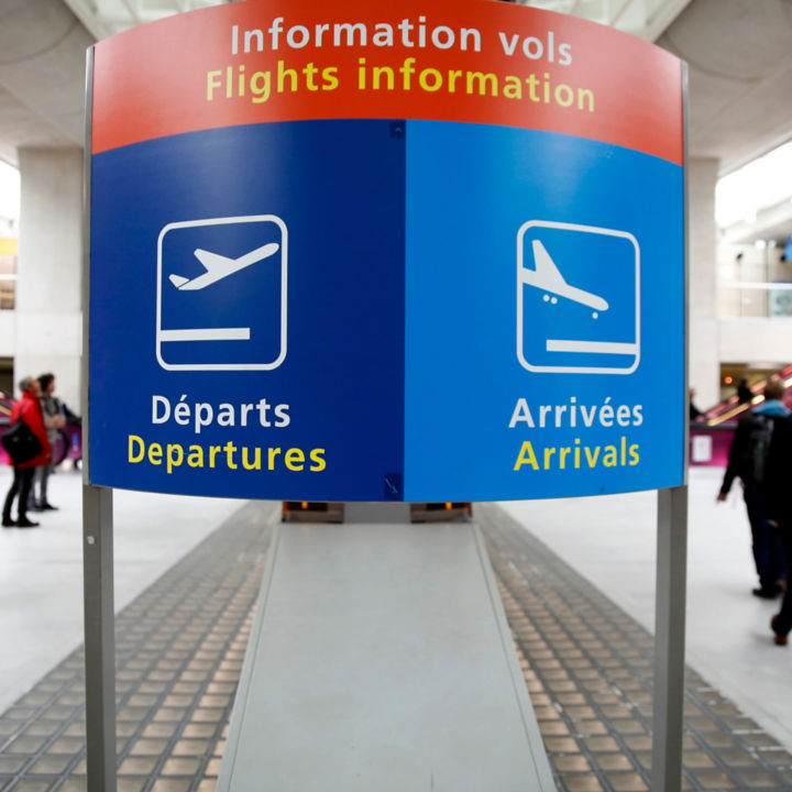 Signage and travellers at the Paris Charles de Gaulle Airport.