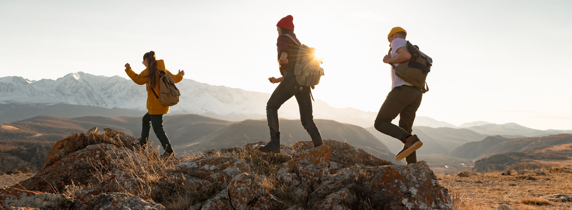 Group of hikers walking in mountains at sunset.