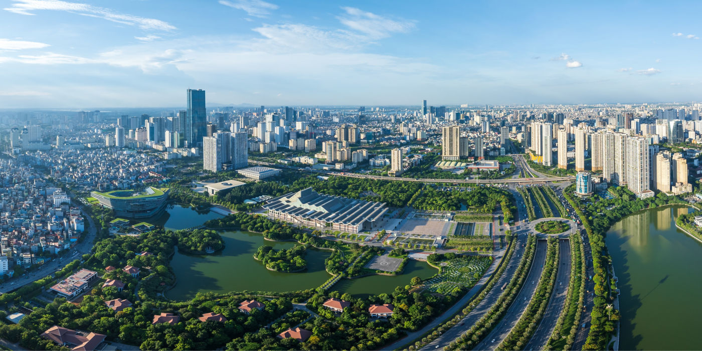 Aerial view of Hanoi with tall and low-rise buildings and greenery.