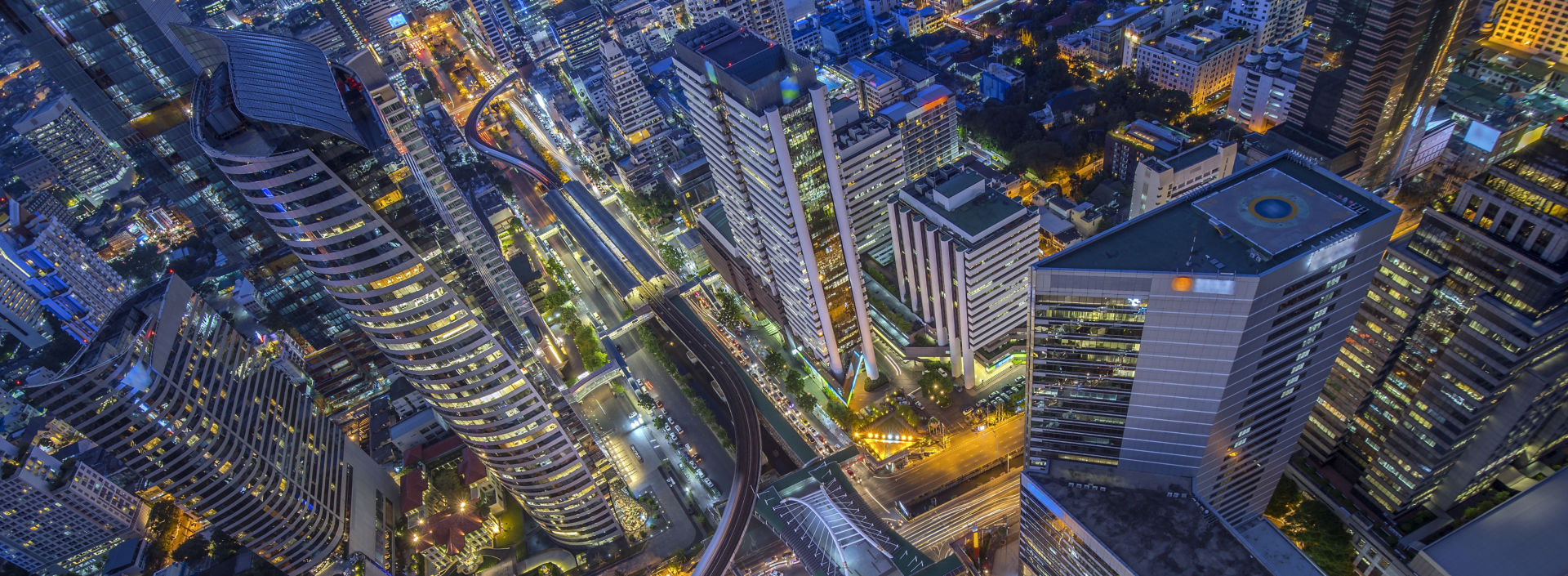 Birds eye view of modern buildings at night in Bangkok.