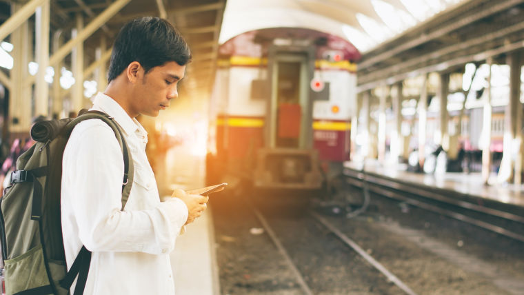 young_man_using_his_phone_in_the_train_station:760x428%2816-9%29