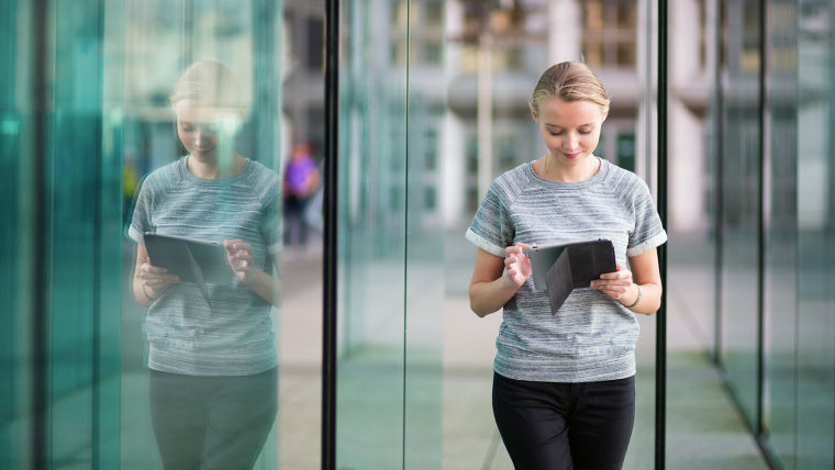 young_woman_in_modern_glass_office_interior_using_tablet:760x428%2816-9%29